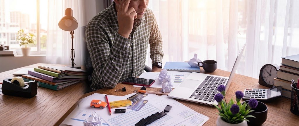Person reviewing personal loan paperwork next to a credit card while comparing borrowing options
