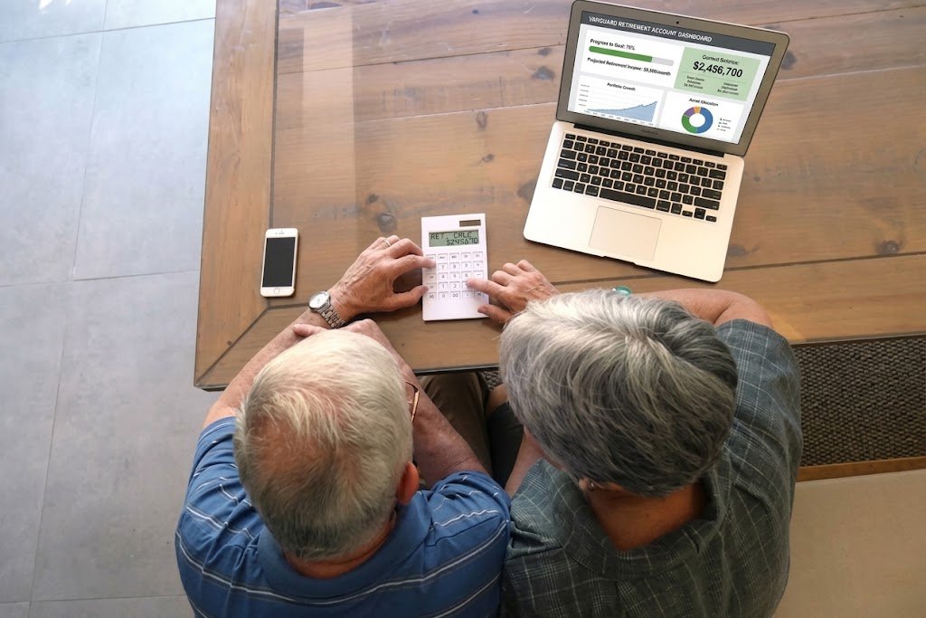 Person reviewing 401(k) employer match contributions on a laptop with a calculator