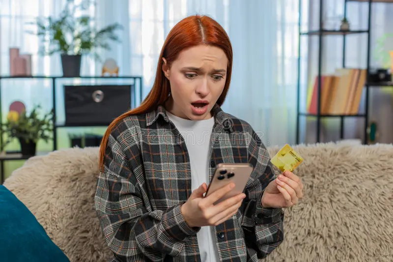 Person experiencing financial anxiety while hesitating to check their bank account balance