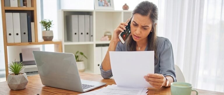 Person preparing for a credit card reconsideration call with a denial letter and notes on the desk