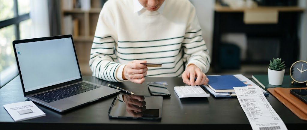 Person checking credit card purchase protection benefits with a new laptop and receipt