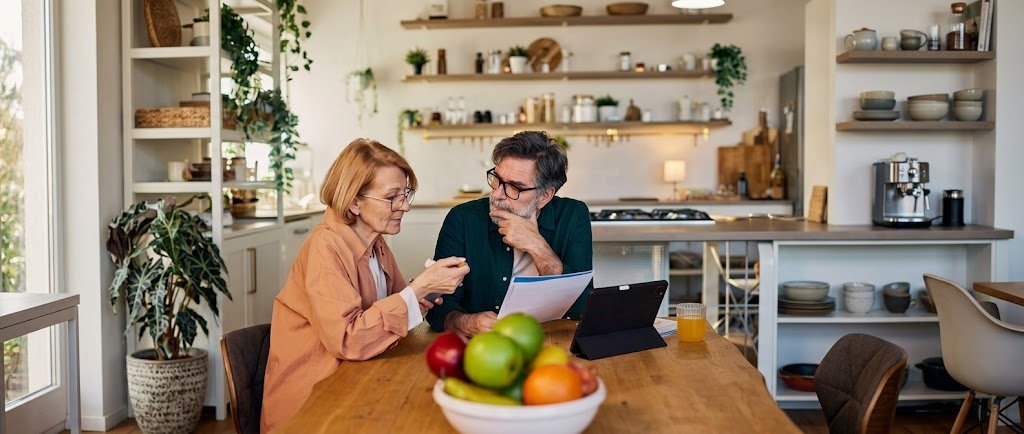Couple in their late 40s reviewing a retirement catch-up plan at a kitchen table