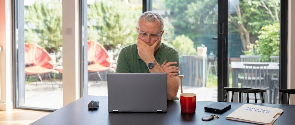 Person reviewing a credit report on a laptop to check for synthetic identity fraud