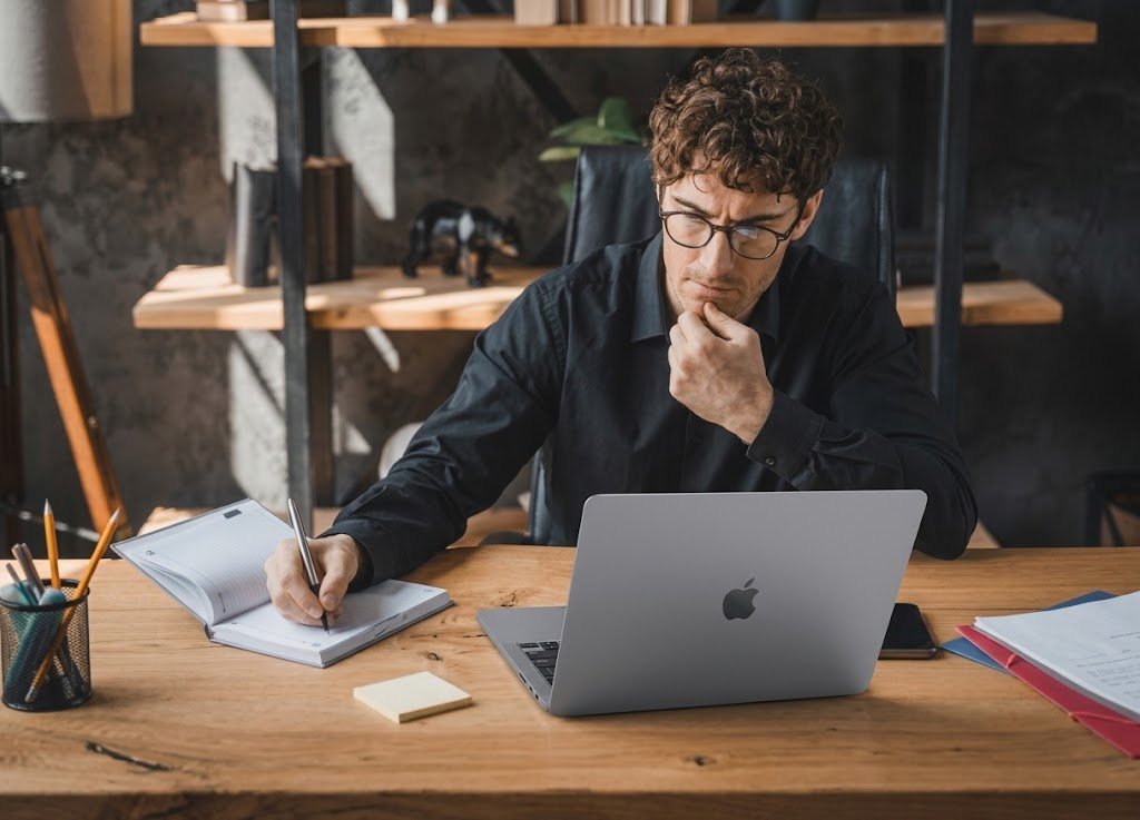 Investor reviewing a portfolio on a laptop to decide whether to borrow against investments instead of selling