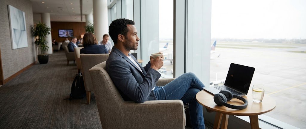 Traveler relaxing with coffee in a quiet space that illustrates airport lounge access