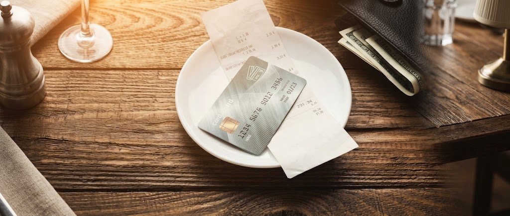 Premium metal credit cards resting on a table beside a receipt and a pen